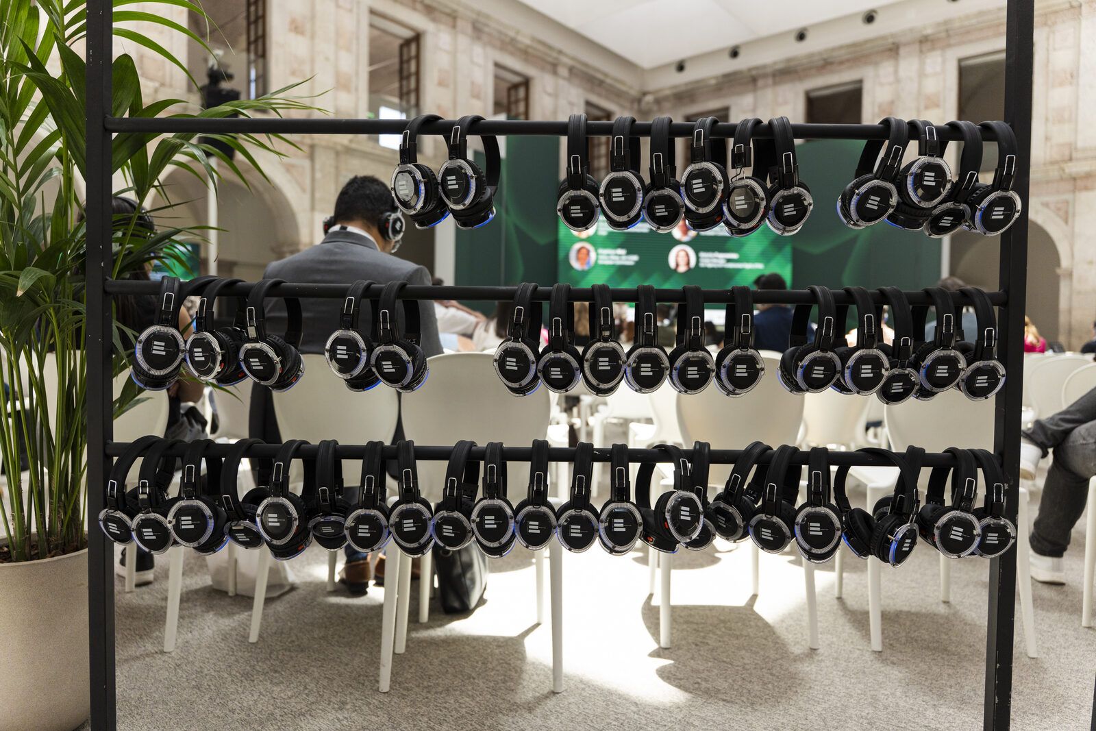 Rows of wireless headsets hanging on racks for simultaneous interpretation at the GASA Europe Summit