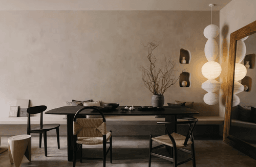 Minimalist lounge dining space in Singapore with dark wood table, woven chairs and paper lantern pendant lights, hosts up to 40 guests