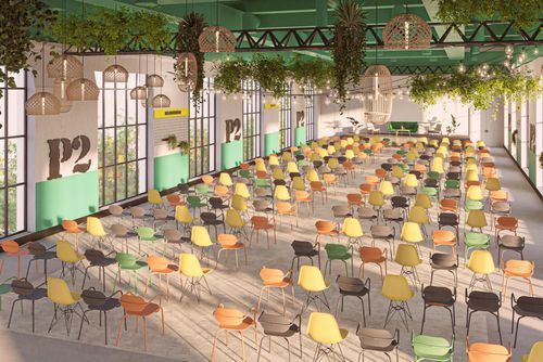 Industrial conference hall in Paris with green metal ceiling beams, hanging plants and rattan lamps, rows of mismatched colourful chairs facing a green stage area.