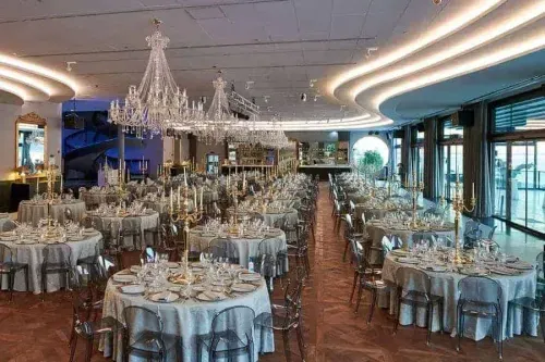Waterfront ballroom in Lisbon with Louis XVI-inspired crystal chandeliers, round banquet tables and floor-to-ceiling windows, hosts up to 750 guests