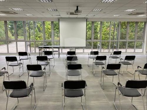 Glass-enclosed event hall in Singapore with garden views, theatre-style seating and modern facilities for conferences and presentations.