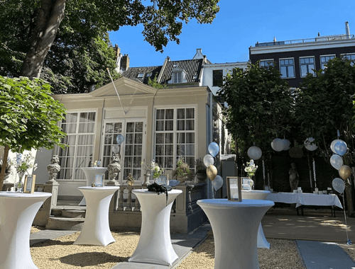 Garden courtyard with a classical pavilion facade, cocktail tables and balloon decorations