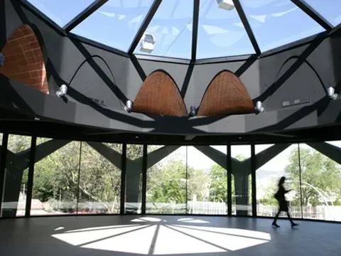 Spherical glass-domed venue in Barcelona with sculptural brick vault details and floor-to-ceiling windows onto gardens, hosts up to 290 guests