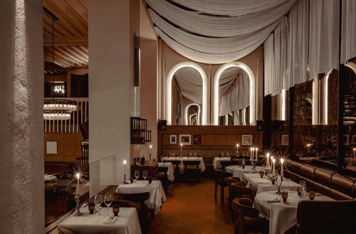 Candlelit Paris event venue with arched mirrored alcoves and draped ceiling