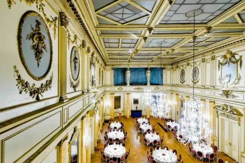 Neoclassical ballroom in Brussels with gilded coffered ceiling, oval murals and round gala tables, hosts up to 400 guests, 360 square metres