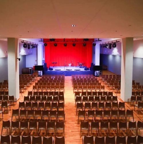 Classical auditorium in Singapore with a red velvet stage curtain and rows of theatre seating, seats up to 600 guests